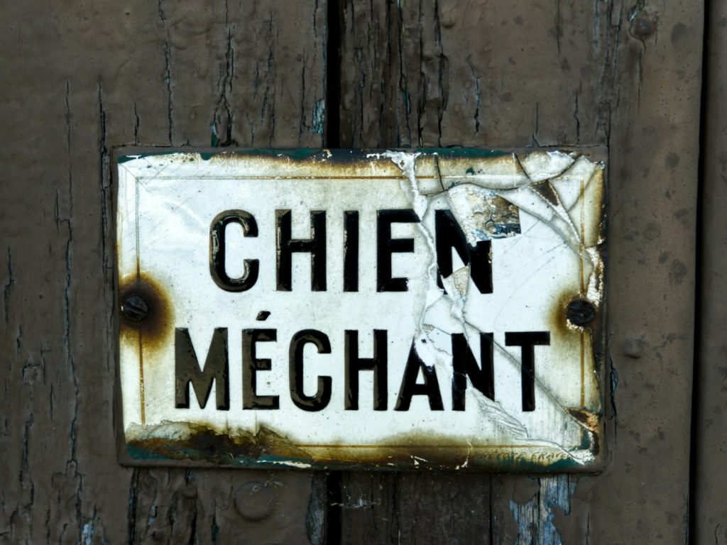 A weathered sign warns "méchant chien."